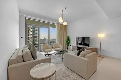a living room with two couches and a table at Waves - Beachfront Bliss - Marina Vista 1BR Escape in Dubai