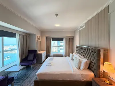 a hotel room with a bed and a chair at Panoramic Fireworks Views with Palm Jumeirah Bluewaters and Ain dubai View in Dubai