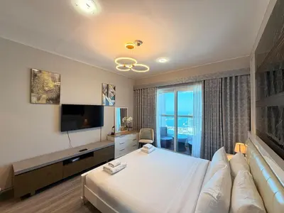 a hotel room with a bed and a television at Panoramic Fireworks Views with Palm Jumeirah Bluewaters and Ain dubai View in Dubai