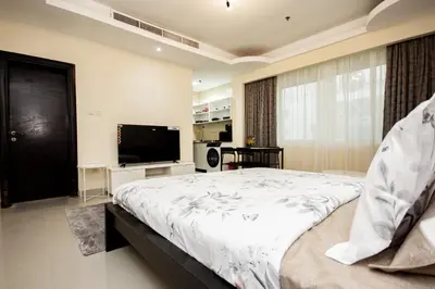 a bedroom with a large bed and a flat screen tv at Newly furnished Studio at city tower building in barsha 1 in Dubai