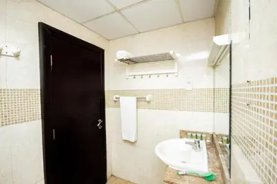 a bathroom with a sink and a black door at Newly furnished Studio at city tower building in barsha 1 in Dubai