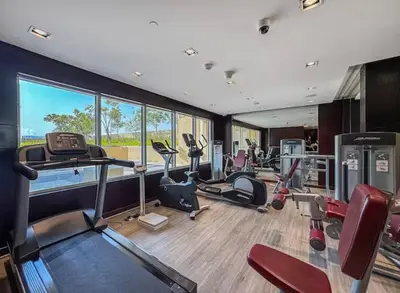 a gym with cardio equipment and a large window at Cove Luxe Holiday Home JVC in Dubai