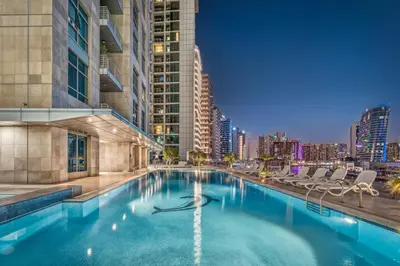 a swimming pool with a city skyline in the background at Modern 1BR Apartment - Burj Khalifa View - Pool & Terrace - Near Metro in Dubai