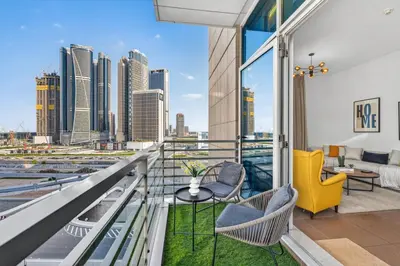 a balcony with chairs and a view of the city at Modern 1BR Apartment - Burj Khalifa View - Pool & Terrace - Near Metro in Dubai