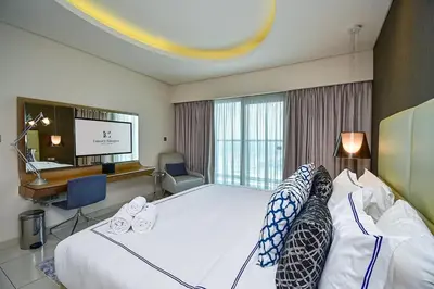 a hotel room with a large bed and a desk at Luxury Escapes Premium 1BR - Paramount Tower Business Bay in Dubai
