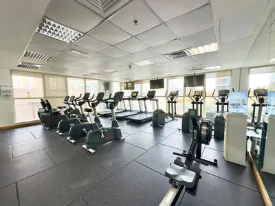 a gym with rows of treadmills and elliptical machines at Charming 2BR in Dubai Marina with Lake View in Dubai