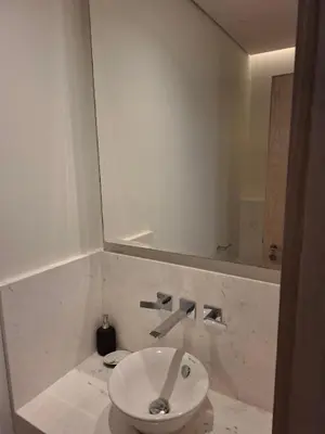 a bathroom with a white sink and a mirror at Luxury 1BR in The Palm Tower Near Nakheel Mall in Dubai
