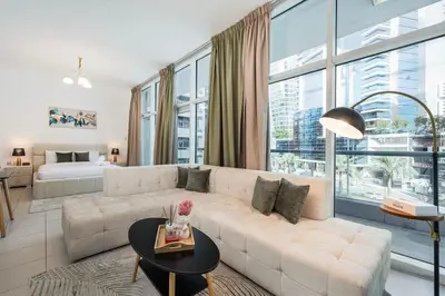 a living room with a white couch and a large window at Urban apartment near to Dubai mall & Burj Khalifa in Dubai