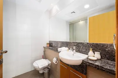 a bathroom with a sink and a toilet and a mirror at Urban apartment near to Dubai mall & Burj Khalifa in Dubai