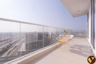 a balcony with a table and chairs and a view at Vogue Al Furjan Gemz by Danube near Ibn Battuta Mall, Three Bedroom plus Kids room Apartment with Balcony and Private Pool, Access to all amenities in Dubai