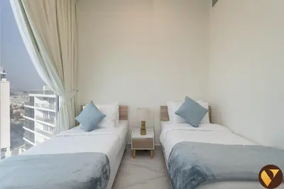 two beds in a room with a window at Vogue Al Furjan Gemz by Danube near Ibn Battuta Mall, Three Bedroom plus Kids room Apartment with Balcony and Private Pool, Access to all amenities in Dubai