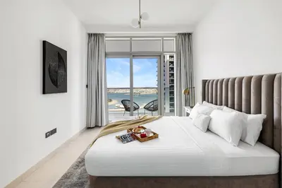 a bedroom with a bed with a view of the ocean at 2BR Beachfront Retreat with Palm and Dubai Eye Views in Dubai