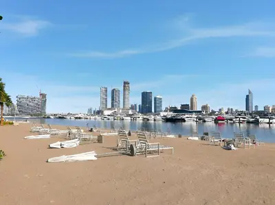 a sandy beach with lounge chairs and boats in the water at 2BR Beachfront Retreat with Palm and Dubai Eye Views in Dubai