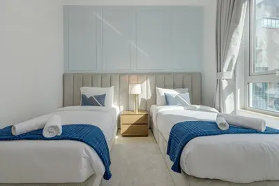 two beds in a room with two windows at Burj Khalifa View - 2 Bedroom apartment at The Residence 5, Downtown - Allsopp & Allsopp in Dubai