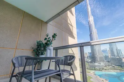 a balcony with two chairs and a table and a view of a city at Burj Khalifa View - 2 Bedroom apartment at The Residence 5, Downtown - Allsopp & Allsopp in Dubai