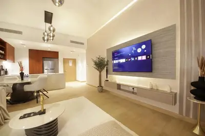 a living room with a large flat screen tv on a wall at Stylish Apartment in Le Pont Jumeirah Near Beach in Dubai