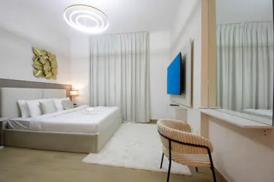 a bedroom with a bed and a tv and a chair at Stylish Apartment in Le Pont Jumeirah Near Beach in Dubai