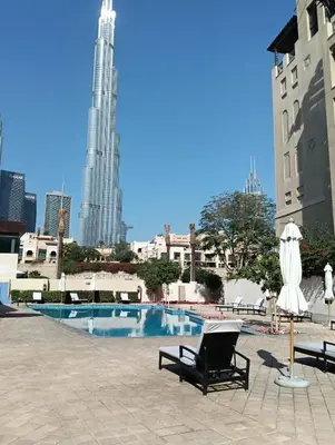a swimming pool with two lounge chairs and a building at Stylish Apartment in Le Pont Jumeirah Near Beach in Dubai