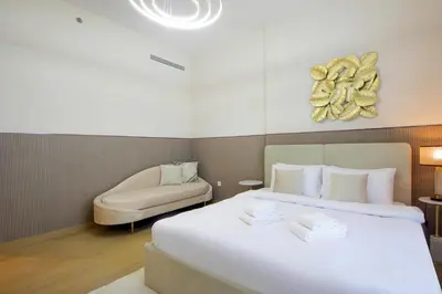a hotel room with a bed and a chair at Stylish Apartment in Le Pont Jumeirah Near Beach in Dubai