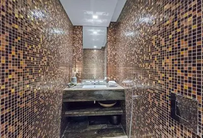 a tiled bathroom with a sink and a mirror at Marina Sky Luxe Penthouse in Dubai