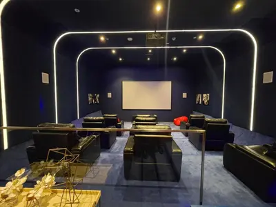 a living room with black furniture and a white screen at Marina Sky Luxe Penthouse in Dubai