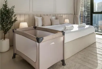 a large white bed in a room with a window at Blissful Stays - Luxury Two Bedroom Apartment at ACT Tower 2, Boulevard, Burj Khalifa, Pool, Near Dubai Mall in Dubai