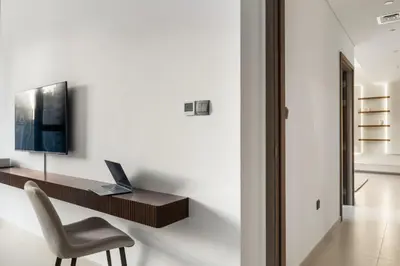 a desk with a laptop and a chair in a room at Blissful Stays - Luxury Two Bedroom Apartment at ACT Tower 2, Boulevard, Burj Khalifa, Pool, Near Dubai Mall in Dubai