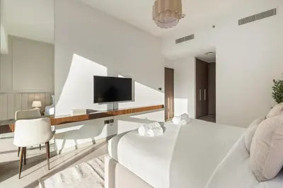 a bedroom with a bed and a desk with a tv at Blissful Stays - Luxury Two Bedroom Apartment at ACT Tower 2, Boulevard, Burj Khalifa, Pool, Near Dubai Mall in Dubai