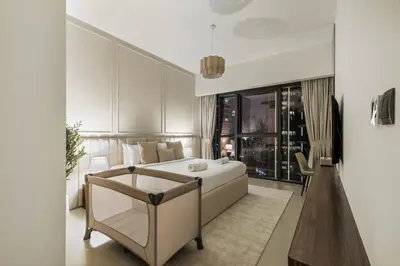 a bedroom with a bed and a chair and a window at Blissful Stays - Luxury Two Bedroom Apartment at ACT Tower 2, Boulevard, Burj Khalifa, Pool, Near Dubai Mall in Dubai
