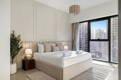 a white bedroom with a large bed and a window at Blissful Stays - Luxury Two Bedroom Apartment at ACT Tower 2, Boulevard, Burj Khalifa, Pool, Near Dubai Mall in Dubai