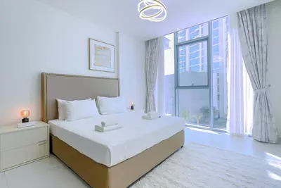a bedroom with a large bed and a large window at TRPS - District One Residences, MBR - Brand New 3BR plus Maids, Lagoon View, Fully Furnished in Dubai