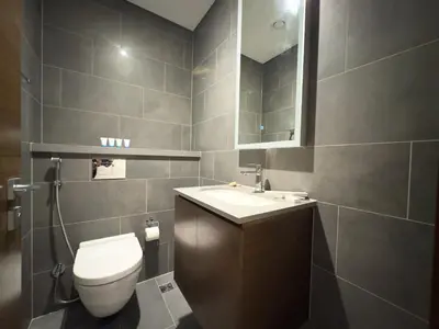 a bathroom with a toilet and a sink and a mirror at Werova-Cozy 2-Bedroom Apartment w Stunning Views in Dubai