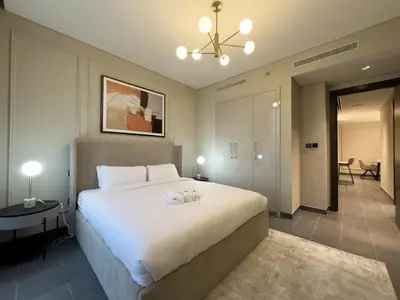 a bedroom with a large white bed in a room at Werova-Cozy 2-Bedroom Apartment w Stunning Views in Dubai