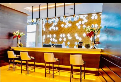 a bar with four chairs and a counter with flowers at Luxury Fendi with Stunning Marina Views in Dubai
