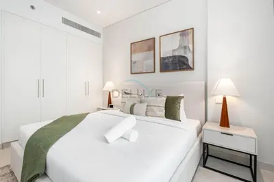 a white bedroom with a large bed and two lamps at Steps from the Park, Mall and The Green Planet, Minutes to Metro with Easy Access to Downtown Attractions, Myrtle, Al Wasl by Deluxe Holiday Homes in Dubai