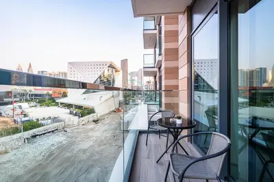 a balcony with tables and chairs and a view of a city at Steps from the Park, Mall and The Green Planet, Minutes to Metro with Easy Access to Downtown Attractions, Myrtle, Al Wasl by Deluxe Holiday Homes in Dubai