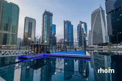 a pool in the middle of a city with tall buildings at Brand New 2-BR Panoramic View - Near Marina & JBR in Dubai