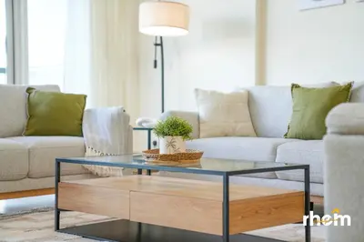 a living room with a couch and a glass coffee table at Brand New 2-BR Panoramic View - Near Marina & JBR in Dubai