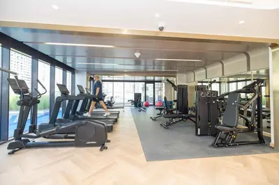 a gym with treadmills and cardio equipment in a building at Bright Studio with Pool Access - Azizi Riviera in Dubai