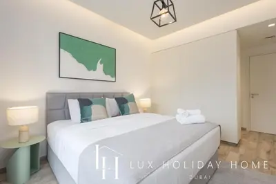 a white bedroom with a bed and a table at LUX The Business Bay Executive Suite in Dubai