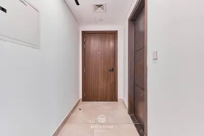 a hallway with a wooden door in a building at Brand New 1B with Burj Khalifa View in Business Bay in Dubai