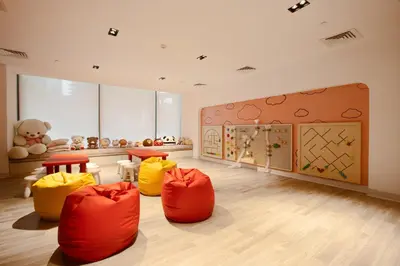 a room with orange and yellow chairs and a kitchen at Brand New 1B with Burj Khalifa View in Business Bay in Dubai