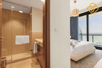 a bathroom with a bed and a glass shower at Seaview 3 BR Burj Vista Connected to Dubai Mall in Dubai