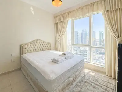 a bedroom with a bed with a large window at Dream Shoma - 2R Serene Apt Direct Marina access in Dubai