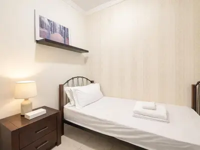 a bedroom with a bed with a nightstand and a tv at Dream Shoma - 2R Serene Apt Direct Marina access in Dubai