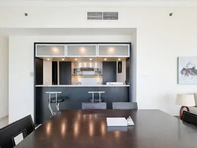a dining room with a table and a kitchen at Dream Shoma - 2R Serene Apt Direct Marina access in Dubai