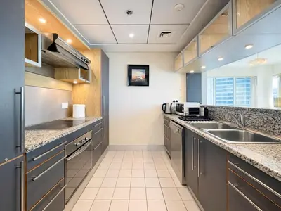 a large kitchen with stainless steel appliances and a sink at Dream Shoma - 2R Serene Apt Direct Marina access in Dubai
