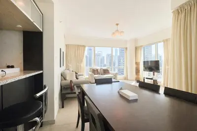 a living room with a table and a living room with a couch at Dream Shoma - 2R Serene Apt Direct Marina access in Dubai