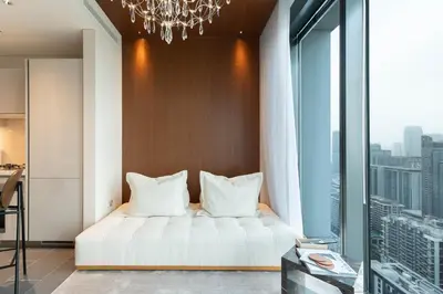 a bedroom with a white bed and a chandelier at Luxury 1BR Retreat near DIFC & Downtown Dubai in Dubai