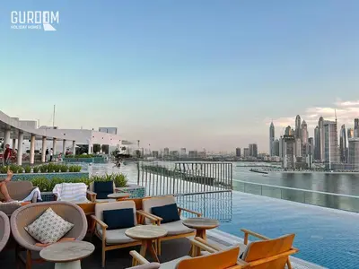 a rooftop patio with chairs and tables and a view of the city at Great Cozy Studio on Palm Jumeirah in Dubai